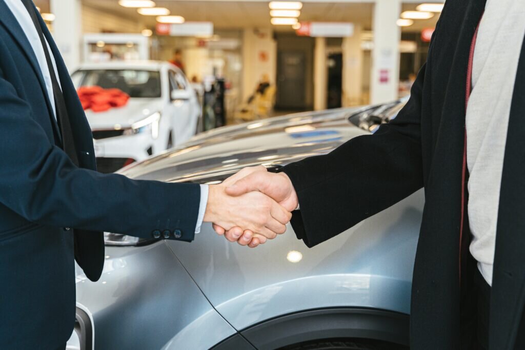 Car sales agent shaking hands