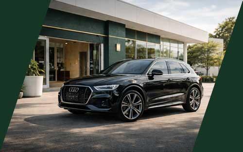 Luxury SUV parked outside a modern dealership with deep green accents, gold highlights, and clean white architecture in natural daylight